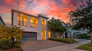 A modern two-story house with a garage, surrounded by well-maintained landscaping and a paved driveway. - 5BR Gorgeous Villa • Spiderman • Near Disney (Kissimmee)