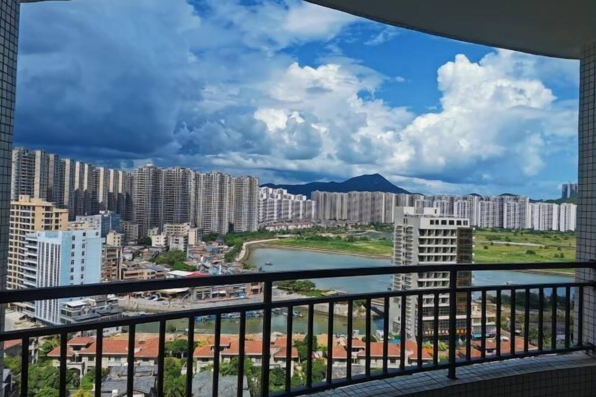 A cityscape with high-rise buildings, a river, and a mountain in the background.