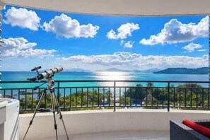 A balcony with a telescope, a view of the sea, and a clear sky. - Genting Coast Resort Apartment (Huidong Country Garden Shili Yintan Branch) (Huidong)