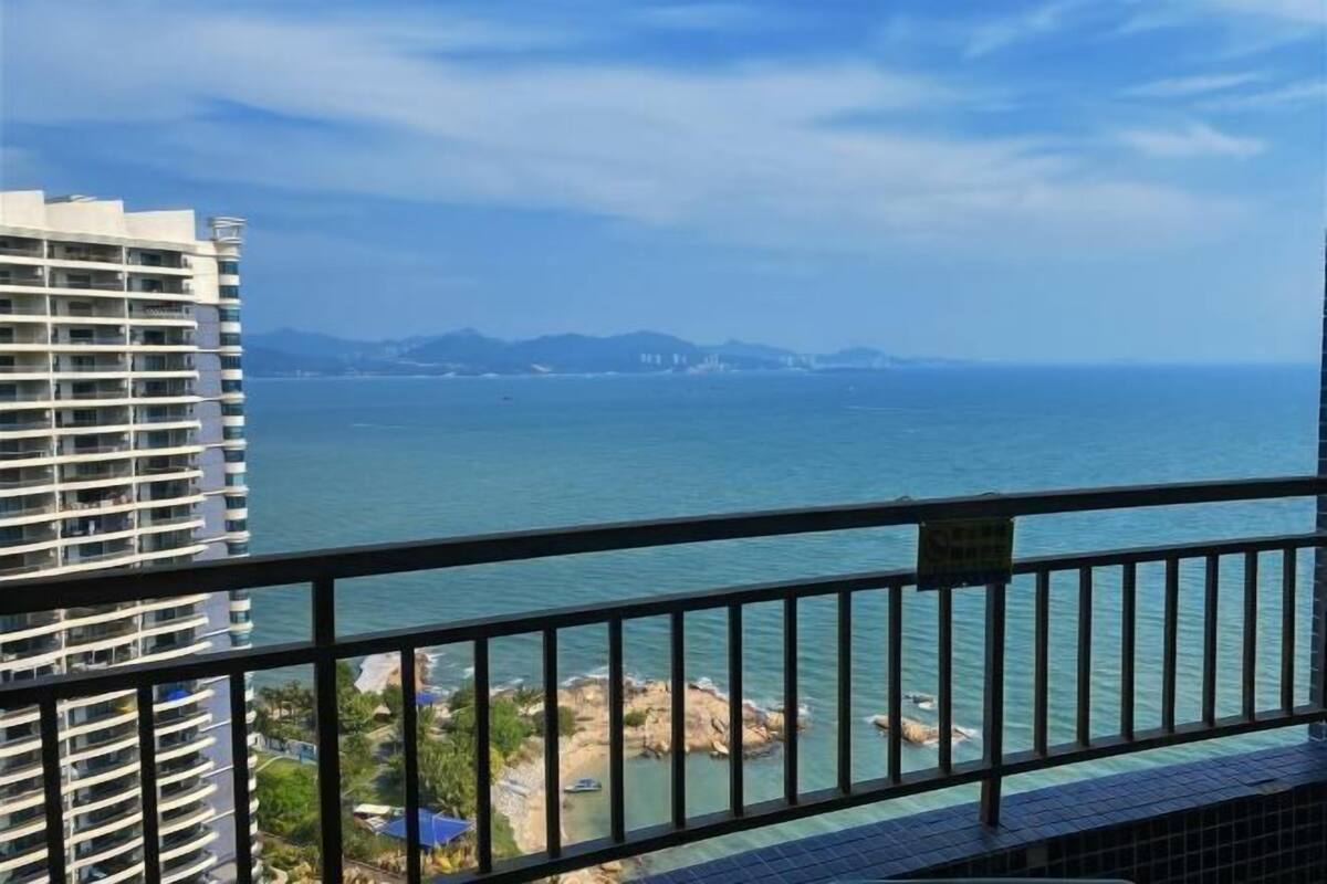 A high-rise building with a view of the sea and distant mountains.