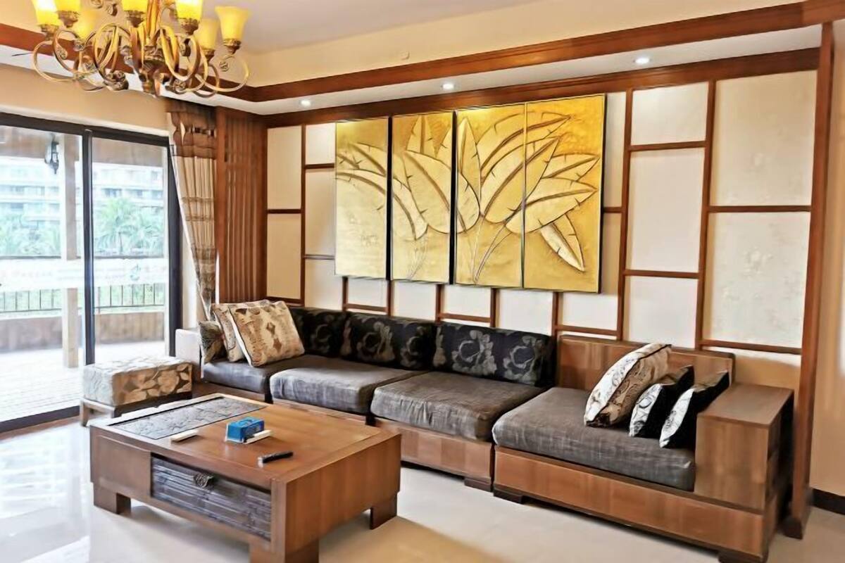 A modern living room with a sofa set, a wooden coffee table, and a decorative wall panel.
