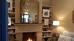 Une chambre à coucher avec une cheminée, des étagères à livres, un lit et une table de chevet.
