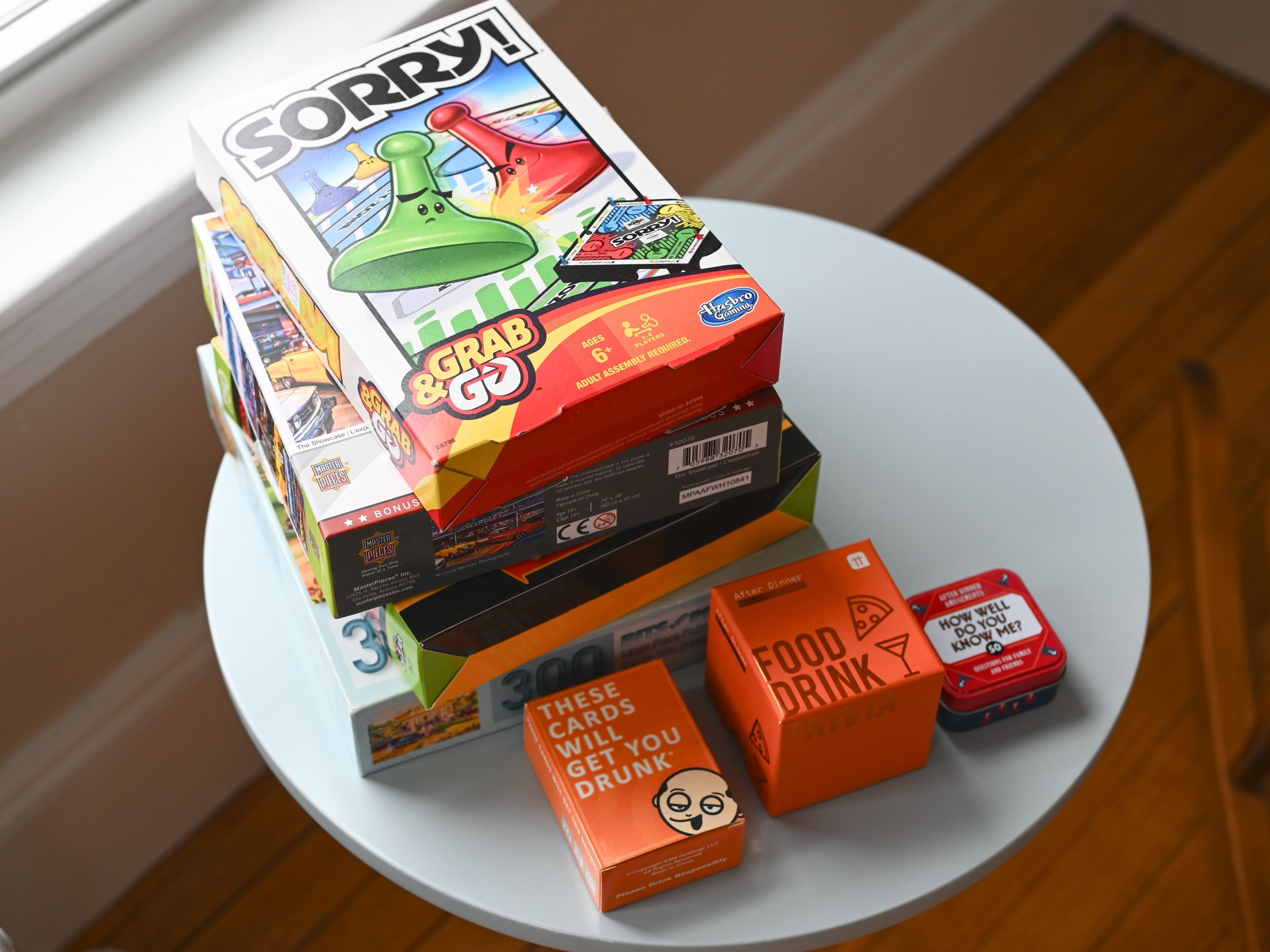 A table with various board games and boxes, including 'Sorry!' and 'Food Drink Trivia'.