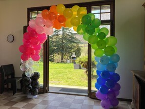 A room with a large glass door leading to a garden, decorated with a rainbow-colored balloon arch. - Charming 3-bedroom bed & breakfast in serene Cenate sotto with WiFi (Cenate sotto)