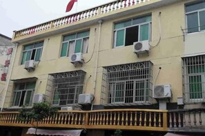 Un immeuble à plusieurs étages doté de balcons, de climatiseurs et de fenêtres grillagées.