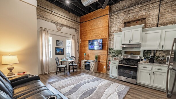 A modern kitchen with white cabinets, a built-in oven, and a stainless steel range hood. - Only Groundfloor access Downtown Laurel - G (Laurel)
