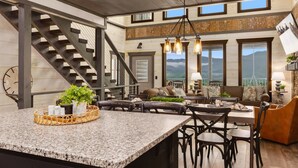 A spacious kitchen with granite countertops, a central island, and a staircase leading to an upper level. - Million $ View|Pool Table|Indr Pool|Games (Sevierville)