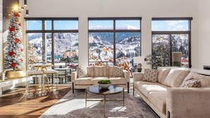 A modern living room with a large window, a Christmas tree, and a sofa. - 5min walk to Gatlinburg|Mtn View|Sauna|Indr Pool|Game| (Gatlinburg)
