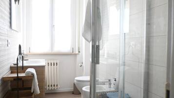 Ein modernes Badezimmer mit Duschkabine, Toilette, Waschbecken und Handtuchheizkörper.