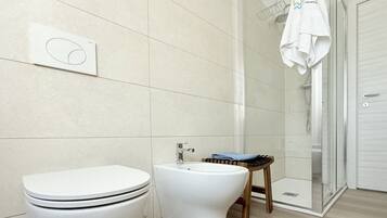 Ein modernes Badezimmer mit Toilette, Bidet und Duschbereich.