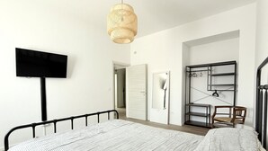 A bedroom with a bed, a television, a hanging light fixture, a wardrobe, and a desk with a chair. - SE163 – Senigallia, new one-bedroom apartment with balcony in the town center (Senigallia)