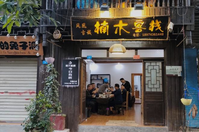 A restaurant with a wooden facade and a signboard above the entrance.