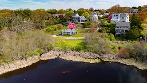 Una propiedad junto al lago con una casa rodeada de árboles y un muelle.