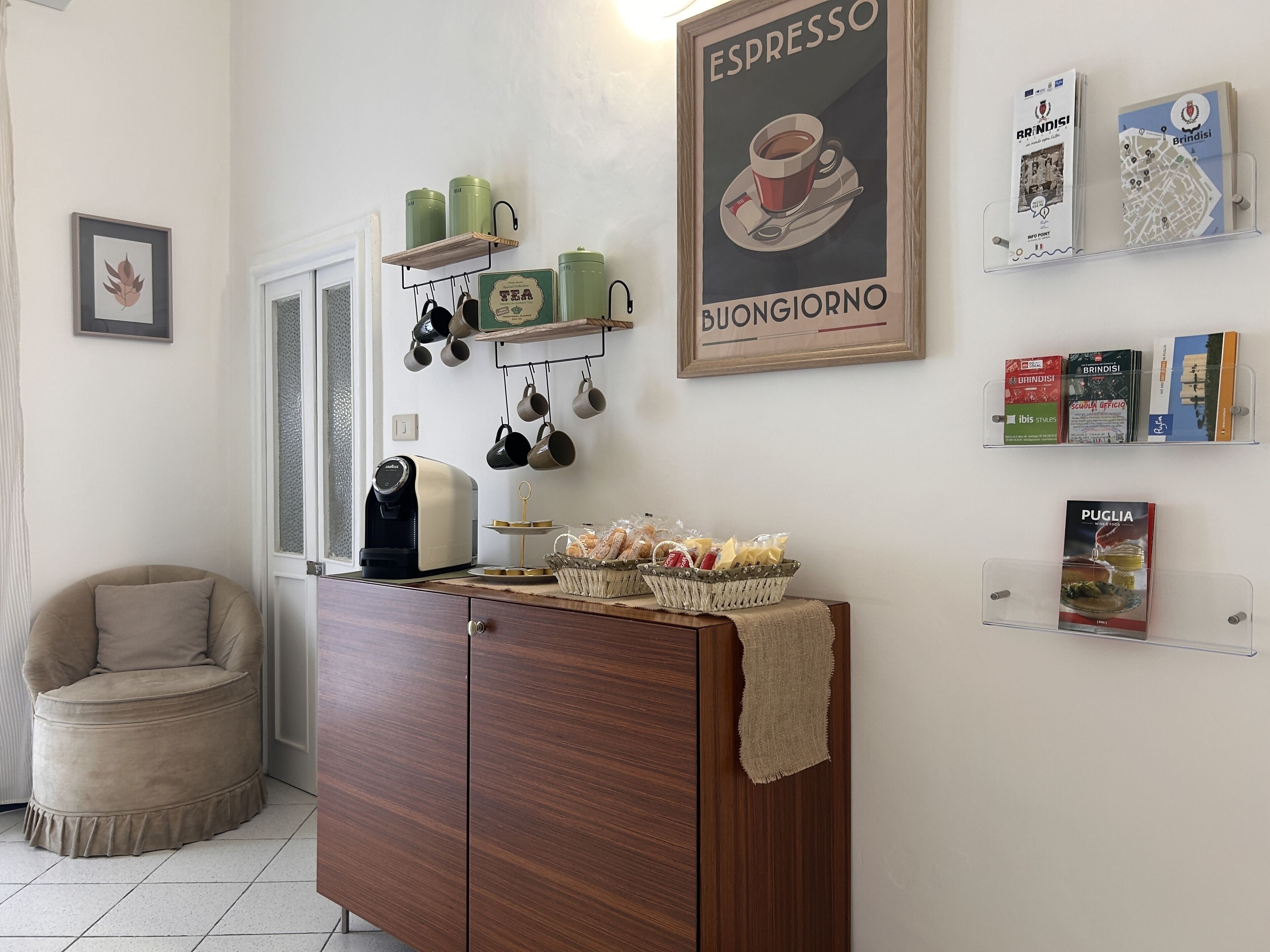 Eine gemütliche Küche mit Kaffeemaschine, aufgehängten Tassen und einem Kaffeeplakat.