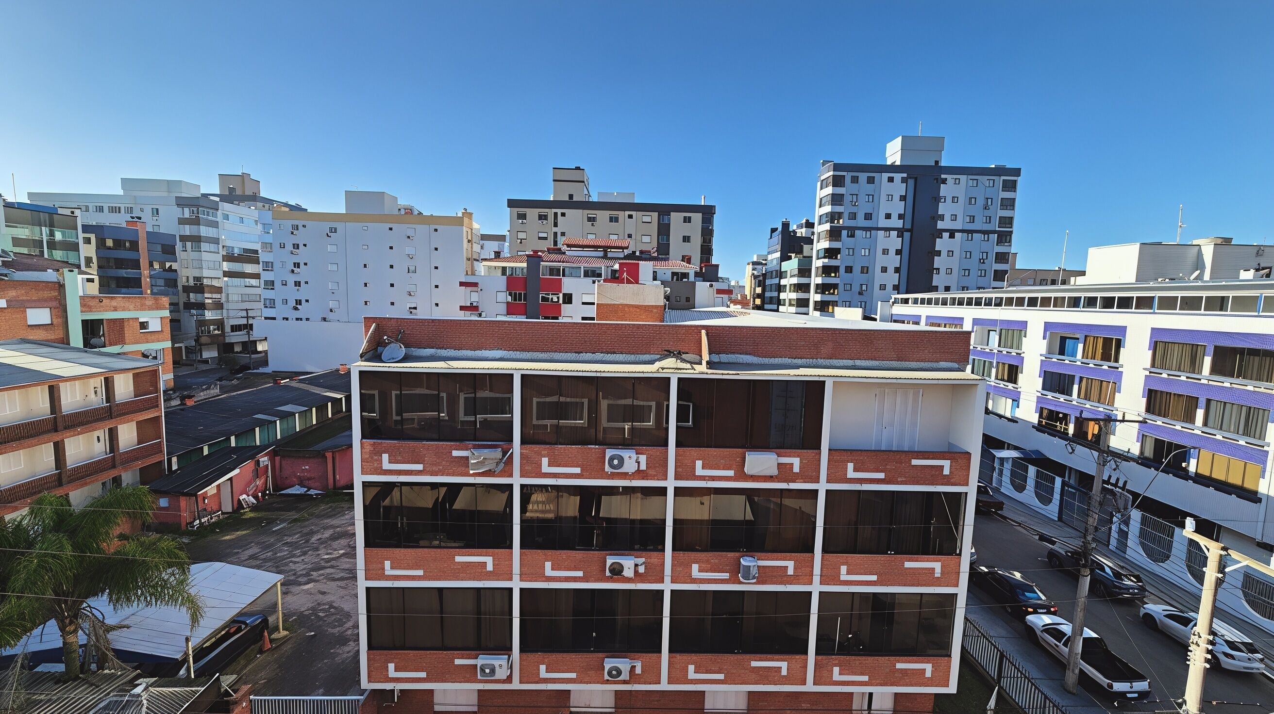 A multi-story building with a brick facade, large windows, and multiple balconies.