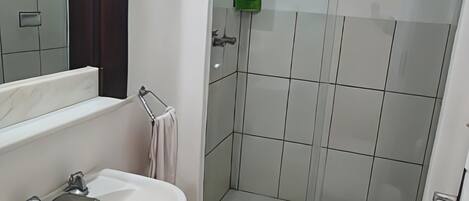 Un baño con lavamanos, inodoro y ducha.
