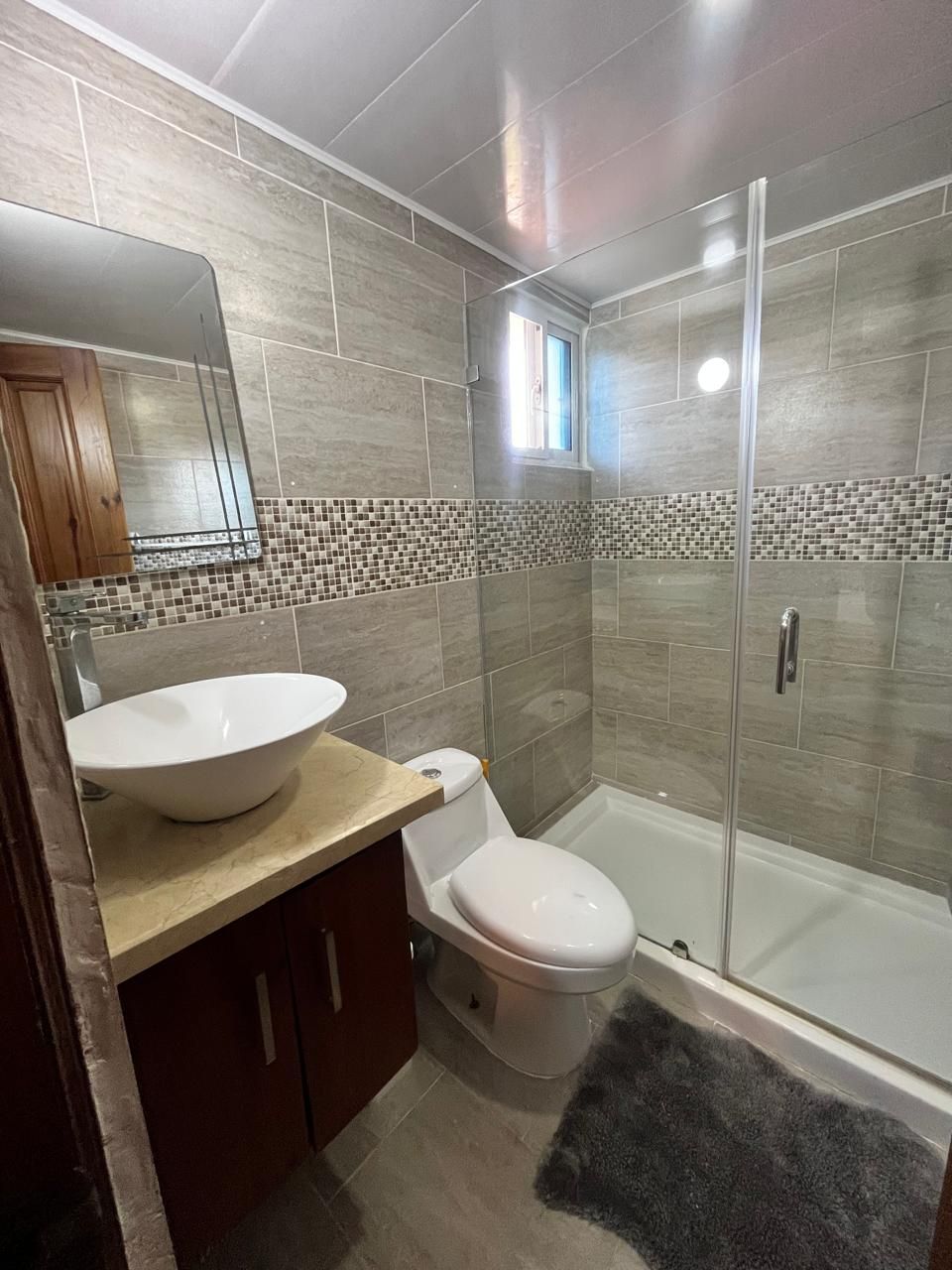 Een moderne badkamer met een groot wastafel, toilet en douchecabine.
