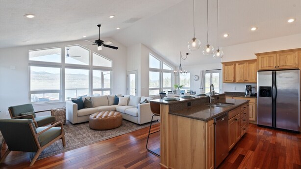 A spacious kitchen with a large island, wooden cabinets, and a stainless steel refrigerator.