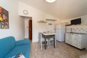 A compact living space with a kitchenette, a dining area, and a sofa.