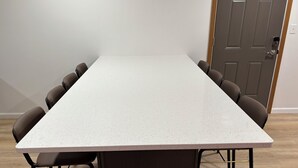 A conference room with a long table and eight chairs.