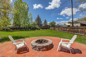 Large backyard with a fire pit and lawn area