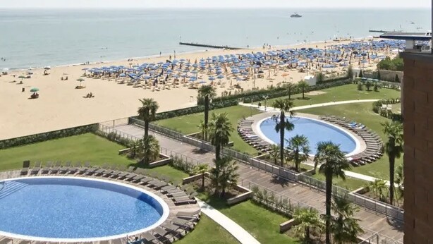 Un complexe hôtelier doté d’une piscine, d’une plage et offrant une vue sur l’océan.