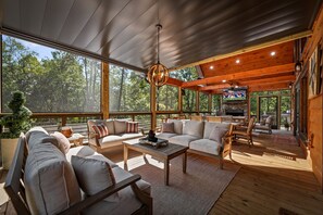 A spacious living area with a large window, a fireplace, and a television.