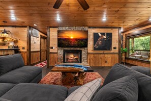 A cozy interior with a fireplace, wooden walls, and a sofa.