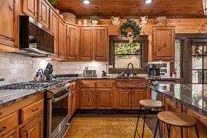 Una cocina moderna con armarios de madera, electrodomésticos de acero inoxidable y una isla central.