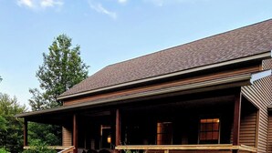 A wooden cabin with a porch, a staircase, and a small garden area. - Romantic couples getaway in awesome Bluford with WiFi, Fireplace, and Game Room (Bluford)