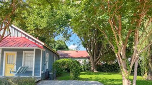 A house with a red roof, a yellow door, and a swing chair outside. - Shanty Bellum Too | 2/1, Washer/Dryer, Full Kitchen (Natchez)