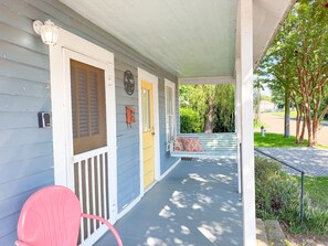 A porch with a bench, a door, and a mailbox.