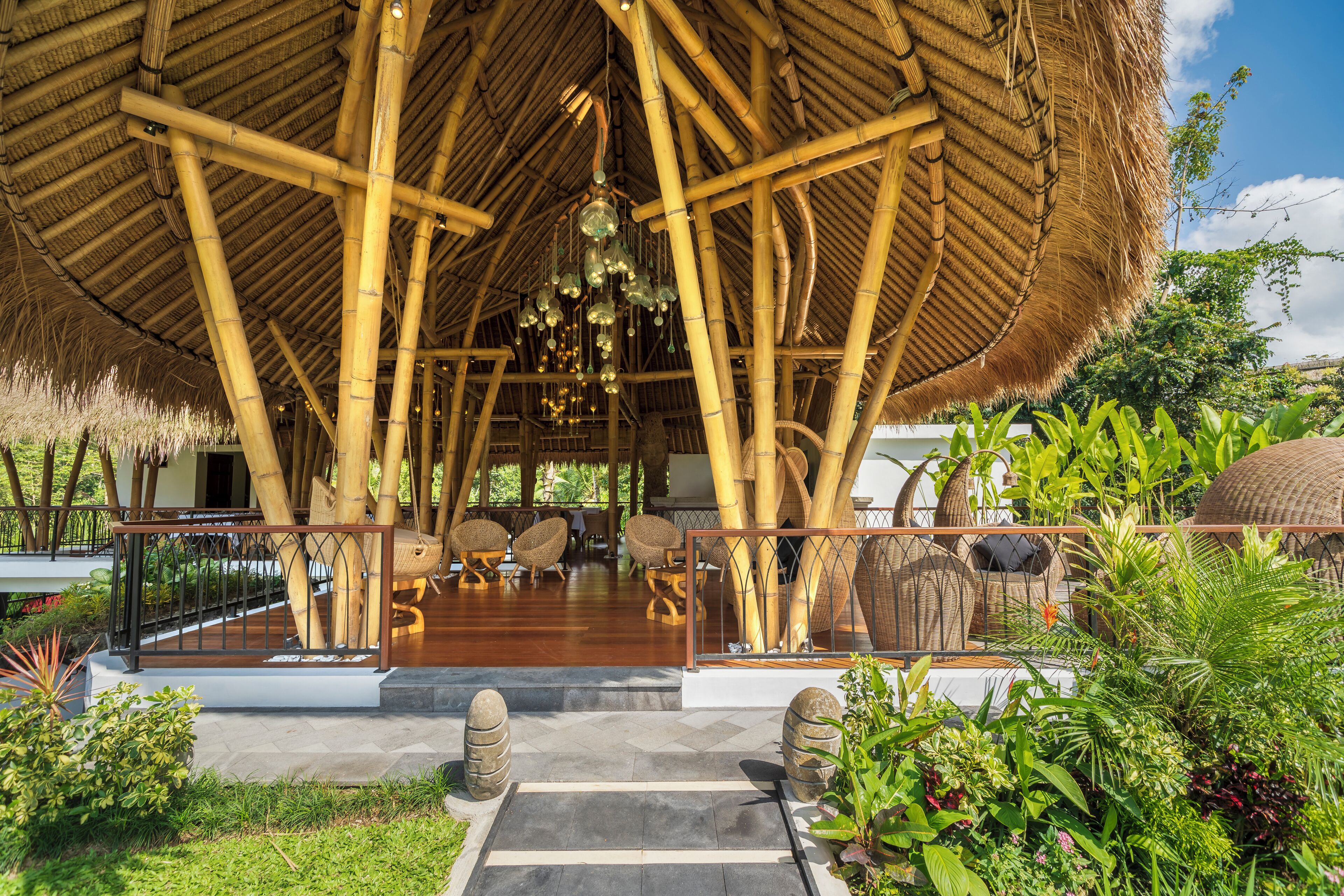 A bamboo structure with seating and a thatched roof.