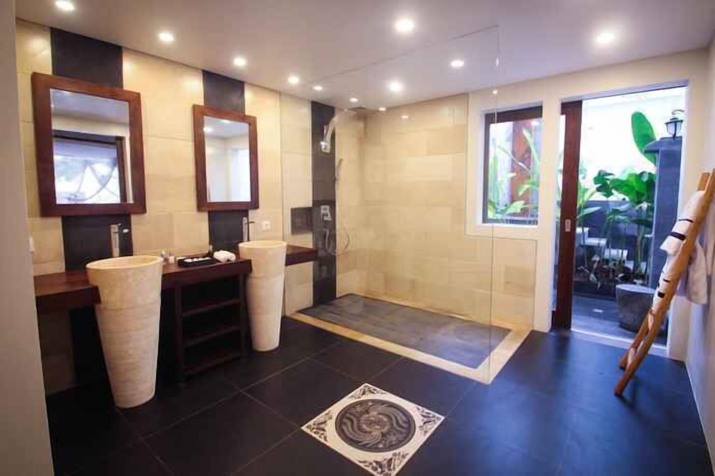 Un bagno moderno con due lavandini, una doccia e un grande specchio.