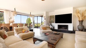 Amplia sala de estar con chimenea, asientos cómodos y un televisor grande.