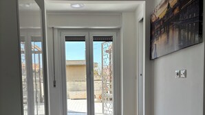Una habitación de hotel con una cama grande, un balcón con vistas y un cuadro en la pared.