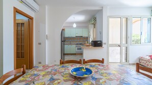 Un espace repas comprenant une table, des chaises et un bol bleu.