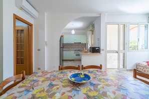 A dining area with a table, chairs, and a blue bowl. - Apartment 'Lorenzo' with Sea View, Wi-Fi and Air Conditioning (Marzamemi)
