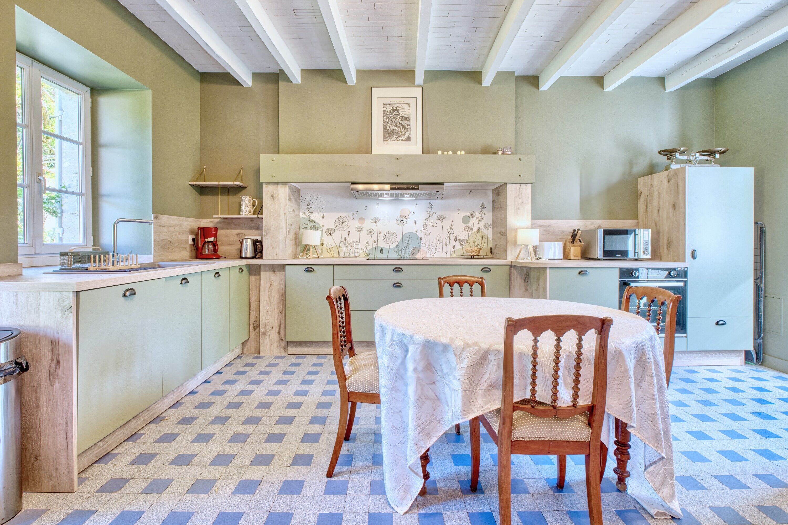 A kitchen with a dining table, chairs, a microwave, and a stove.