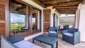 A covered outdoor seating area with wicker furniture, a view of the landscape, and a wooden ceiling. - Villa 'Sofia' with Mountain View, Wi-Fi and Air Conditioning (Punta de Su Turrione)