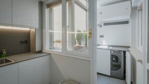 A modern kitchen with a built-in dishwasher, a window with a view, and a countertop with a sink.