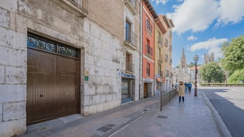 A street with buildings, a large brown gate, and a clear sky.