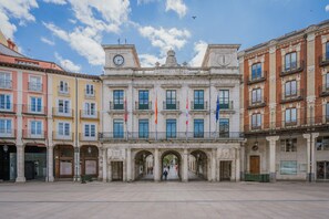 A historic building with a central entrance, columns, and flags.