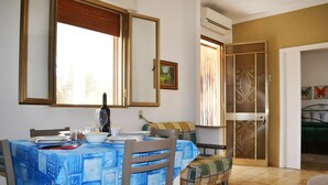 A dining area with a table set for two, a chair, a bench, and a decorative mirror.