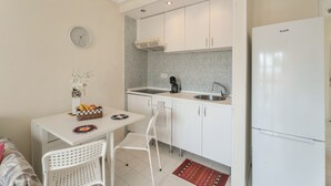 A compact kitchen with white cabinets, a sink, a stove, and a refrigerator. - Vacation Apartment 'Complejo 206' with Sea View, Shared Pool and Wi-Fi (Costa Adeje)