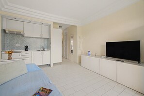 A modern hotel room with a kitchenette, a flat-screen TV, and a sofa. - Vacation Apartment 'Complejo 206' with Sea View, Shared Pool and Wi-Fi (Costa Adeje)