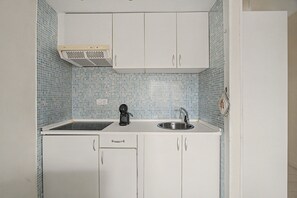 A compact kitchen with white cabinets, a black coffee maker, and a sink. - Vacation Apartment 'Complejo 206' with Sea View, Shared Pool and Wi-Fi (Costa Adeje)