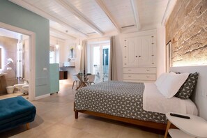 Un dormitorio con cama, mesita de noche y vistas al balcón.