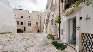A narrow cobblestone street with buildings on either side, some with balconies and others with doors. - Apartment 'Pescatore' with Wi-Fi and Air Conditioning (Monopoli)