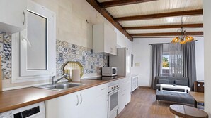 Une cuisine équipée d’un lave-vaisselle, d’un four, d’un four à micro-ondes et d’un coin repas avec une table et des chaises.